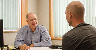 Picture of two men sitting across from one another.